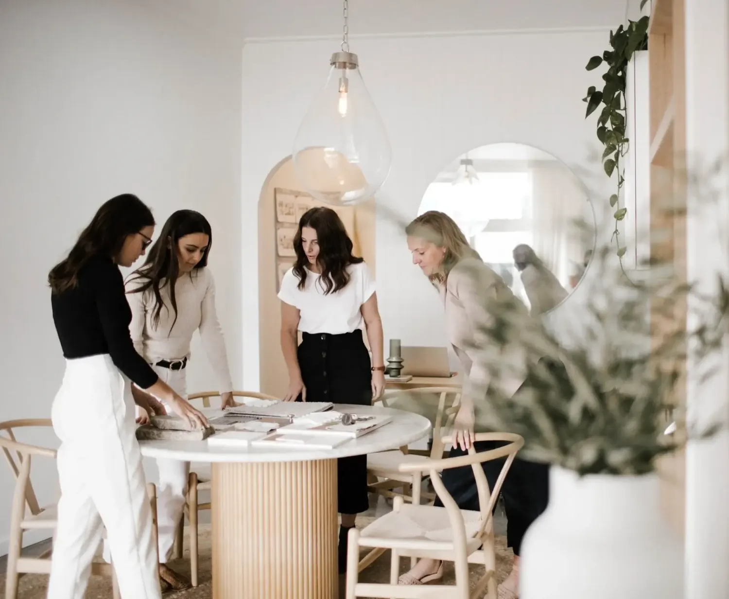 Q + Co design team reviewing material, finish and fixture samples together around a studio table